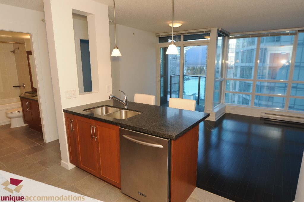 Bright kitchen with granite countertops, hardwood floors, and a city view. - 1802 - 1189 Melville Street, Vancouver Downtown