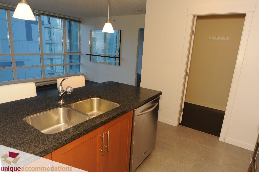 Bright kitchen with granite countertops, stainless steel sink, and city view. - 1802 - 1189 Melville Street, Vancouver Downtown