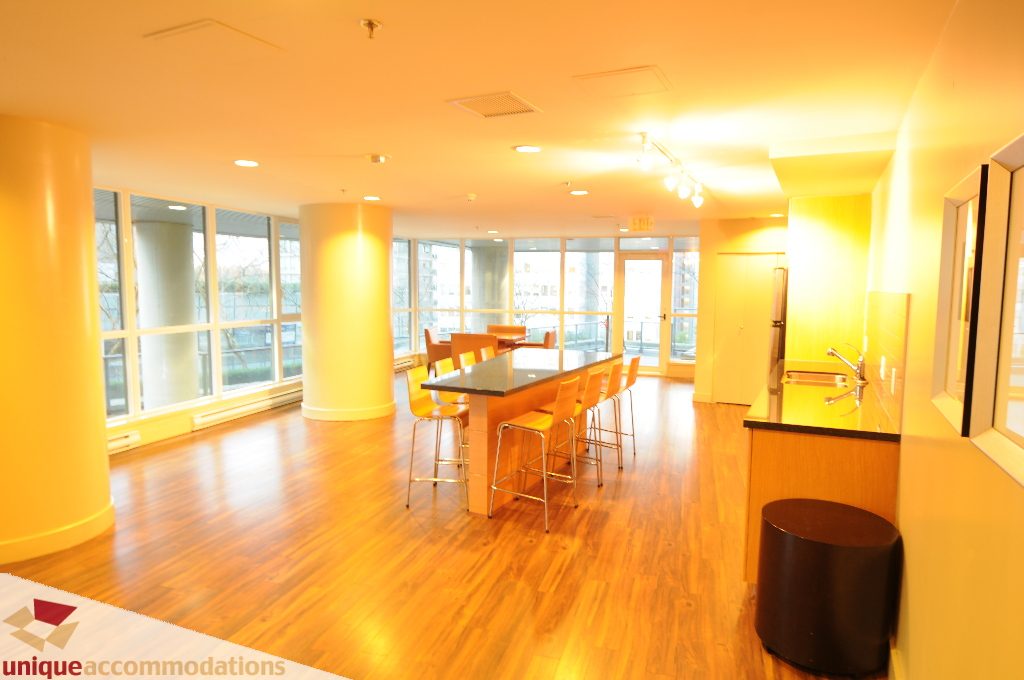 Furnished dining area with hardwood floors, large windows, and city view. - 1802 - 1189 Melville Street, Vancouver Downtown
