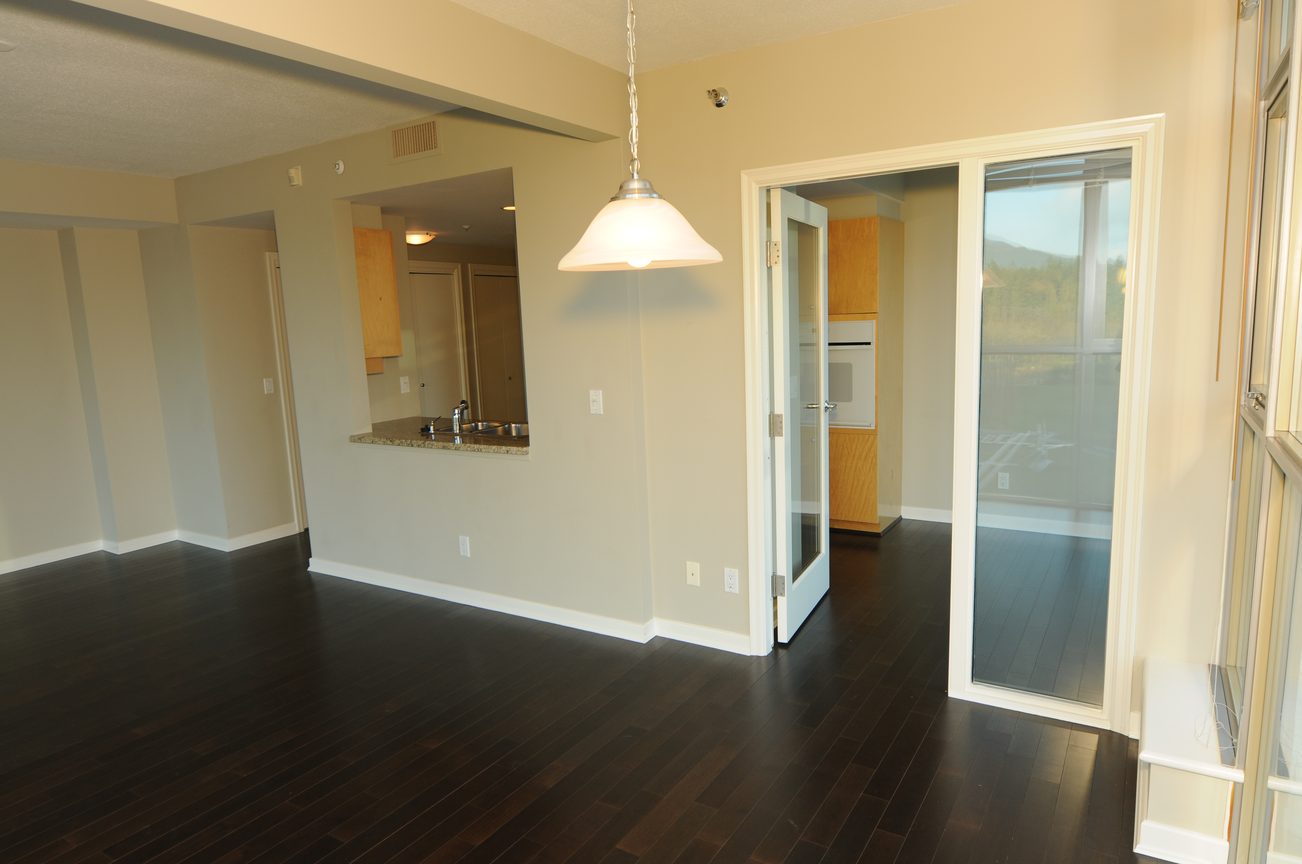 Bright living room with hardwood floors and sliding glass door leading to a balcony with a city view. - 604 - 1790 Bayshore Drive, Vancouver Downtown