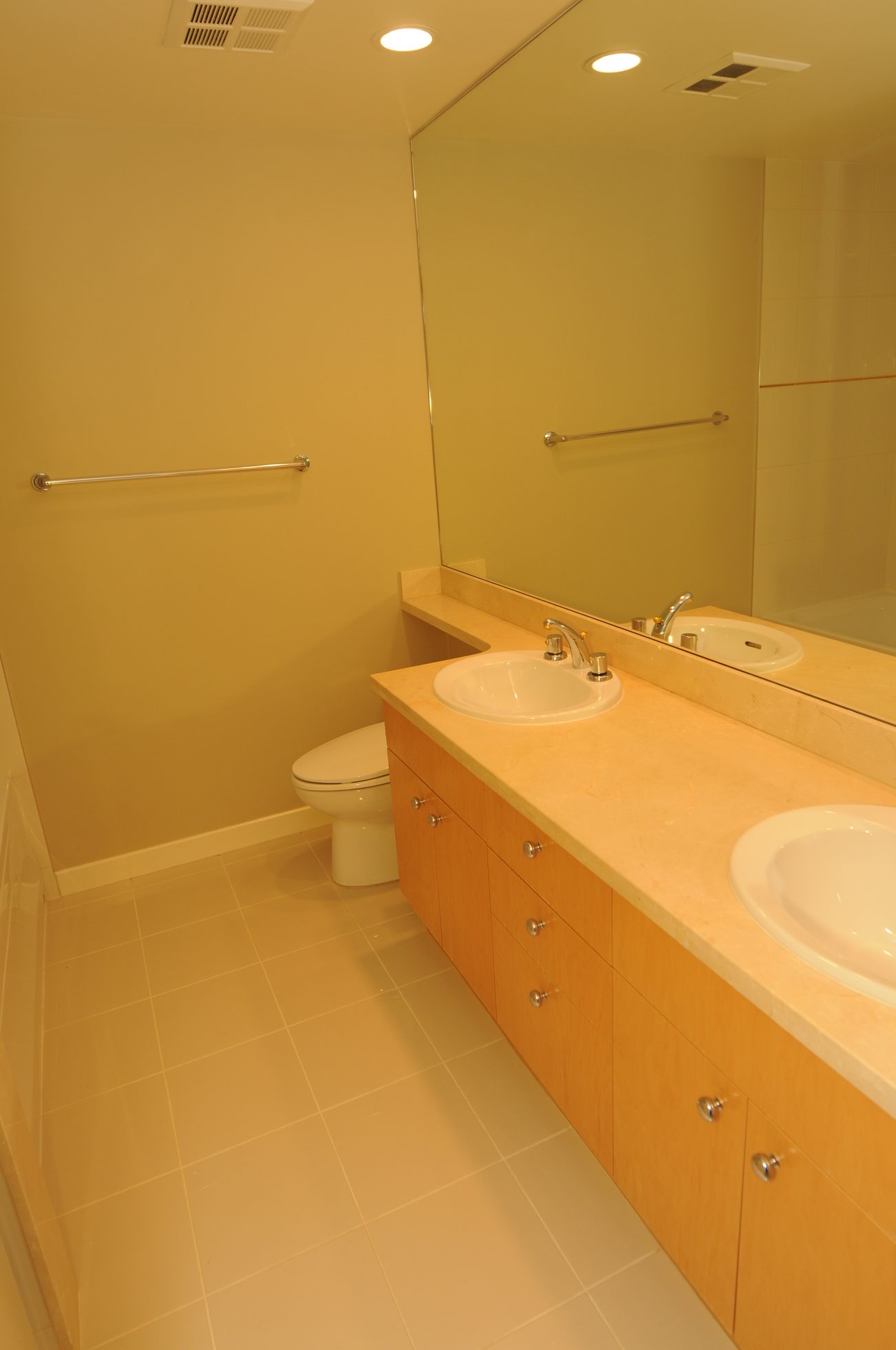 Furnished bathroom with dual sinks, light wood cabinets, and a large mirror. - 604 - 1790 Bayshore Drive, Vancouver Downtown