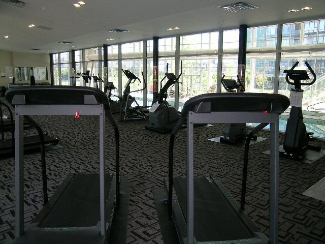 Fitness room with treadmills and large windows showing city view. - 2603 - 1483 Homer Street, Vancouver Downtown