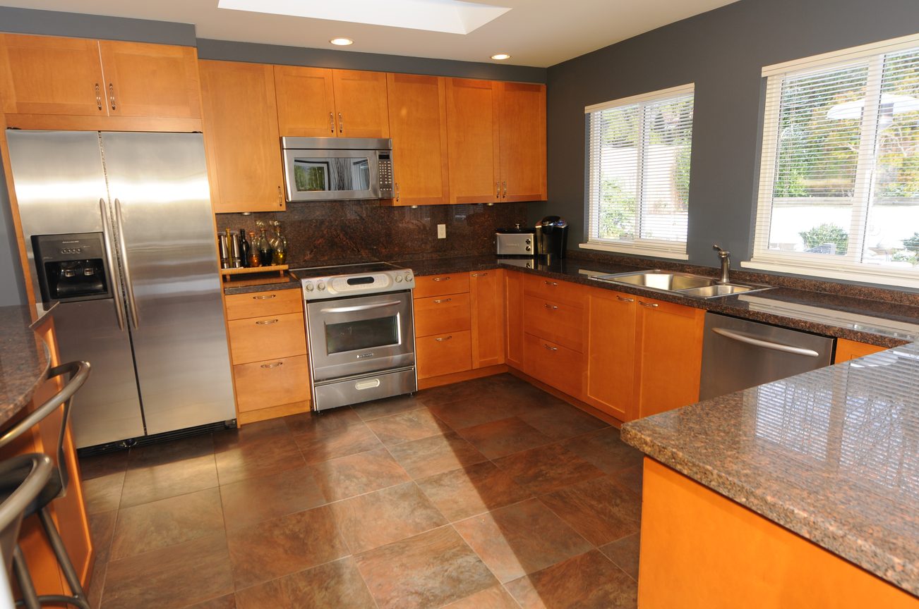 Bright kitchen with granite countertops, stainless steel appliances, and hardwood floors. - 4196 Norwood Avenue, North Vancouver