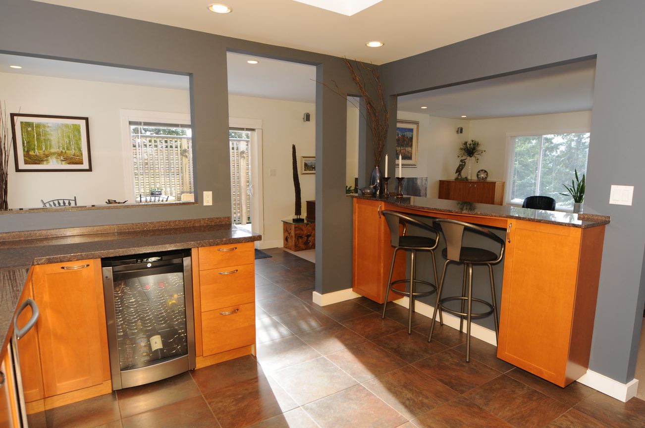 Bright kitchen with granite countertops, wooden cabinets, and a view of the backyard. - 4196 Norwood Avenue, North Vancouver