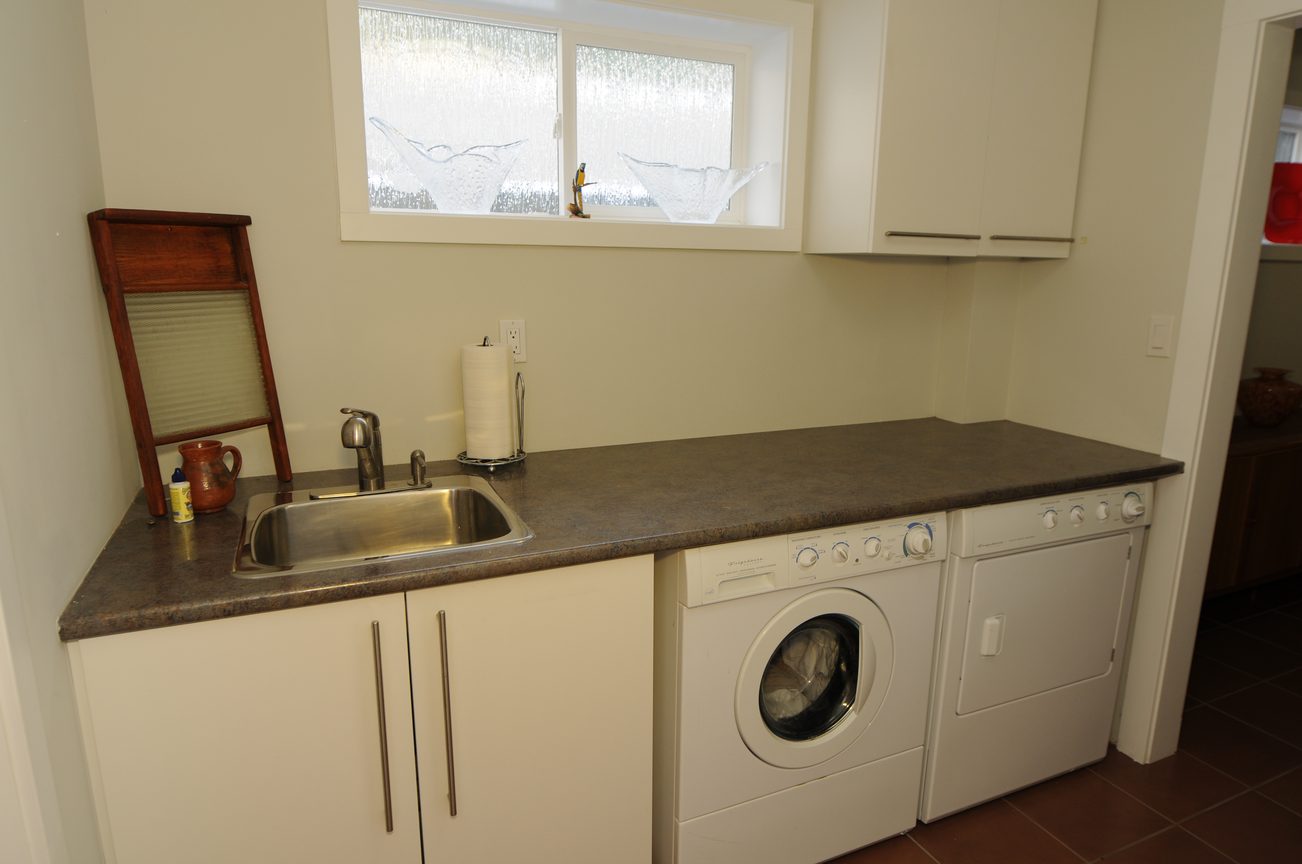 Laundry room with granite countertop and stacked washer/dryer. - 4196 Norwood Avenue, North Vancouver