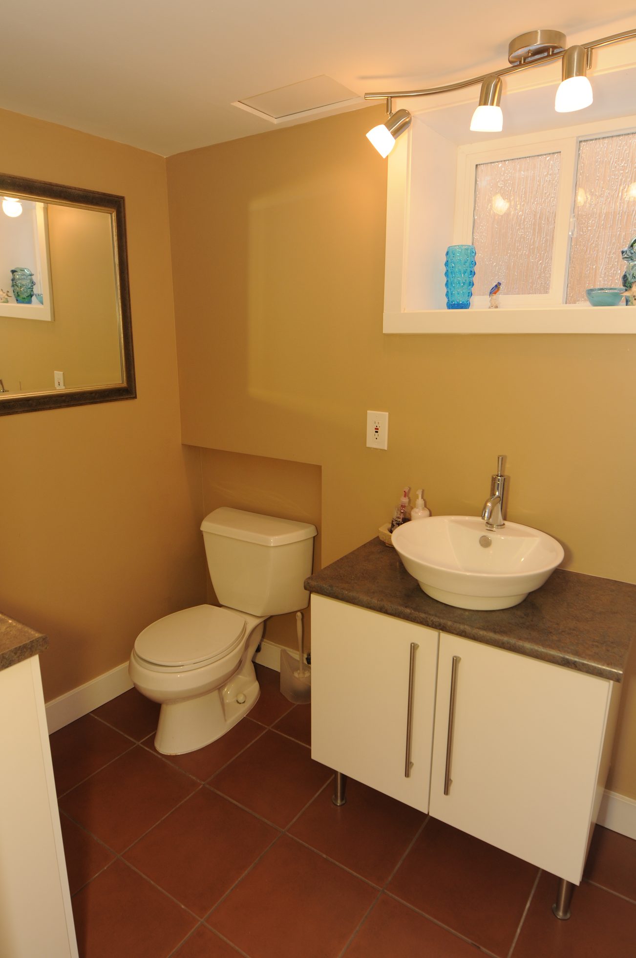Small bathroom with white sink, countertop, and toilet. - 4196 Norwood Avenue, North Vancouver