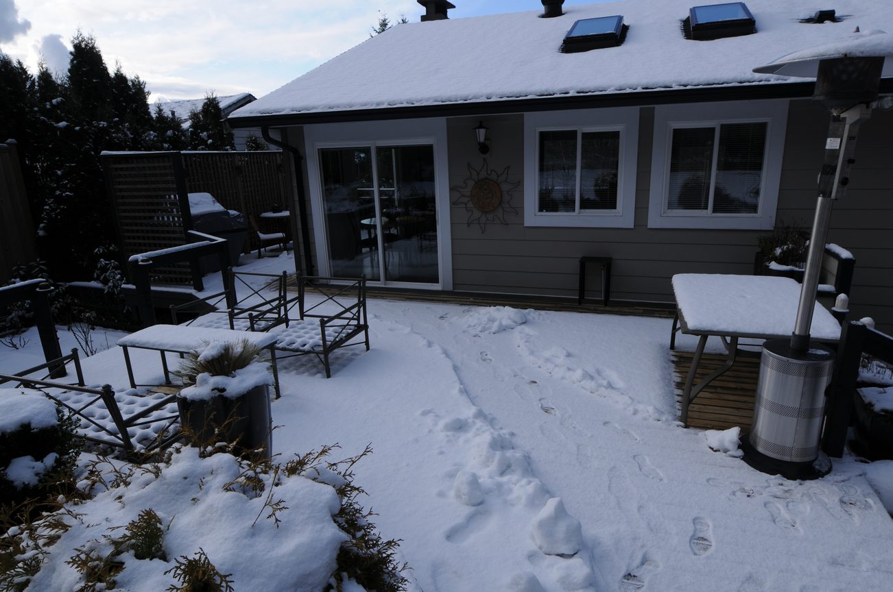Furnished patio with snow-covered furniture and solar panels on roof. - 4196 Norwood Avenue, North Vancouver