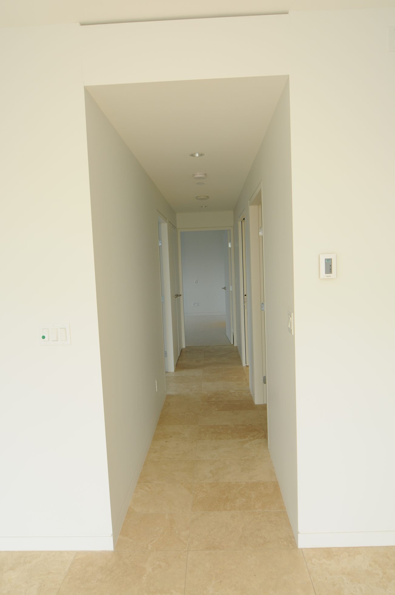 Bright hallway with travertine tile floors and recessed lighting. - 3303 - 838 Hastings Street, Vancouver Downtown