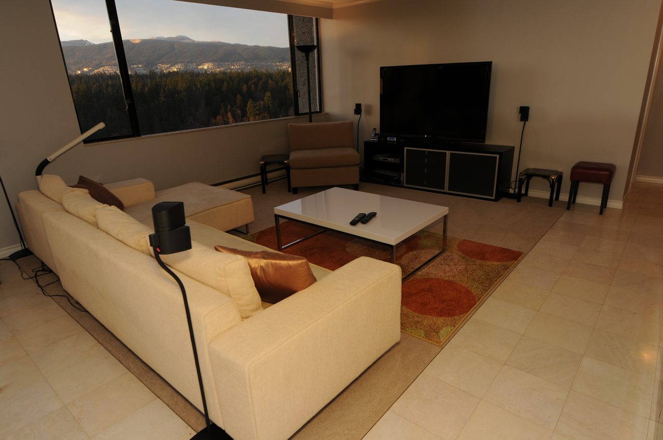 Living room with modern furniture, large window view, and sleek entertainment setup. - 1501 - 845 Chilco Street, Vancouver Downtown