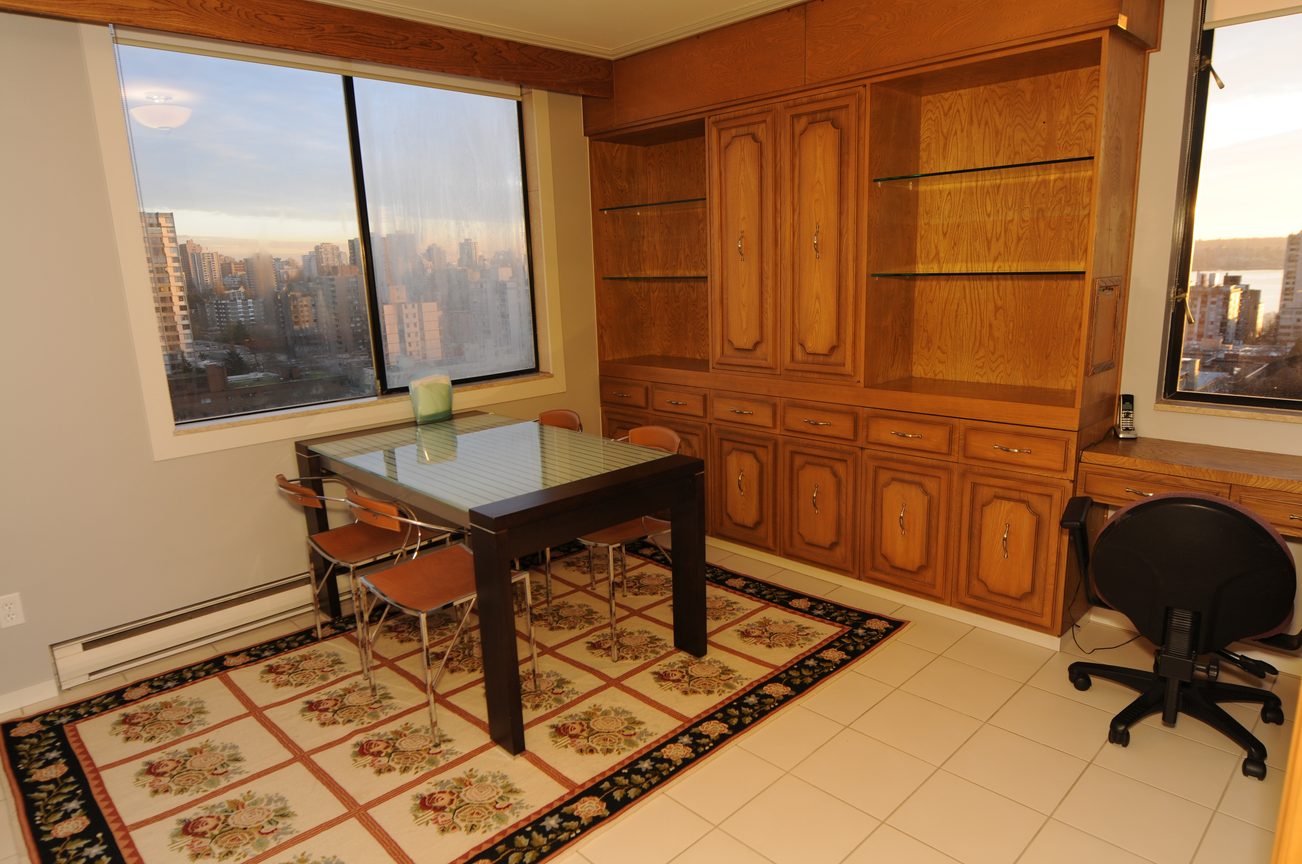 Furnished dining area with wooden cabinets and city view. - 1501 - 845 Chilco Street, Vancouver Downtown