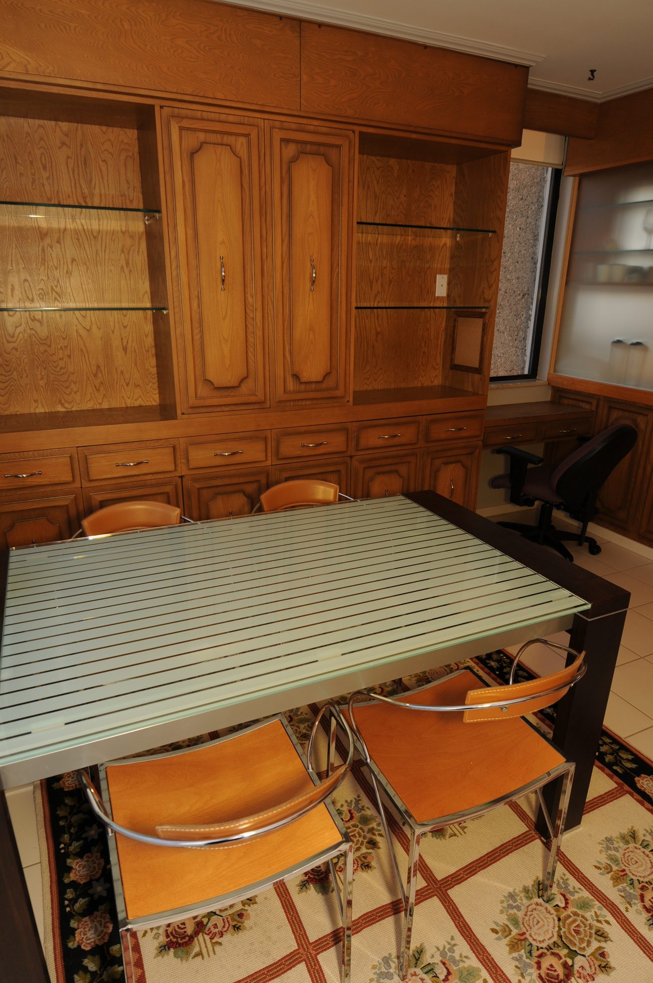 Furnished dining room with wooden cabinets, glass-top table, and leather chairs. - 1501 - 845 Chilco Street, Vancouver Downtown