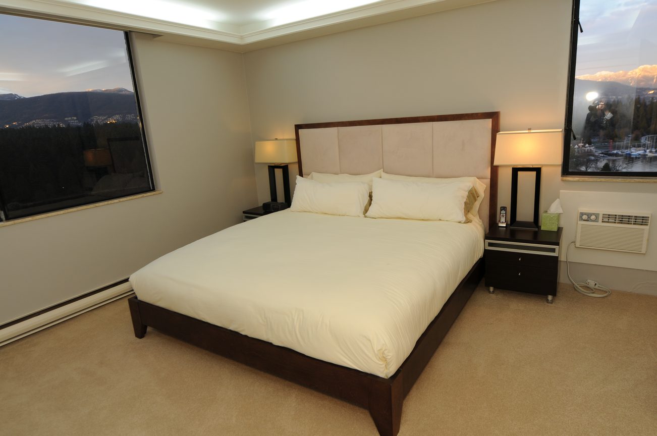 Spacious bedroom with a king-size bed, city view, and modern furnishings. - 1501 - 845 Chilco Street, Vancouver Downtown