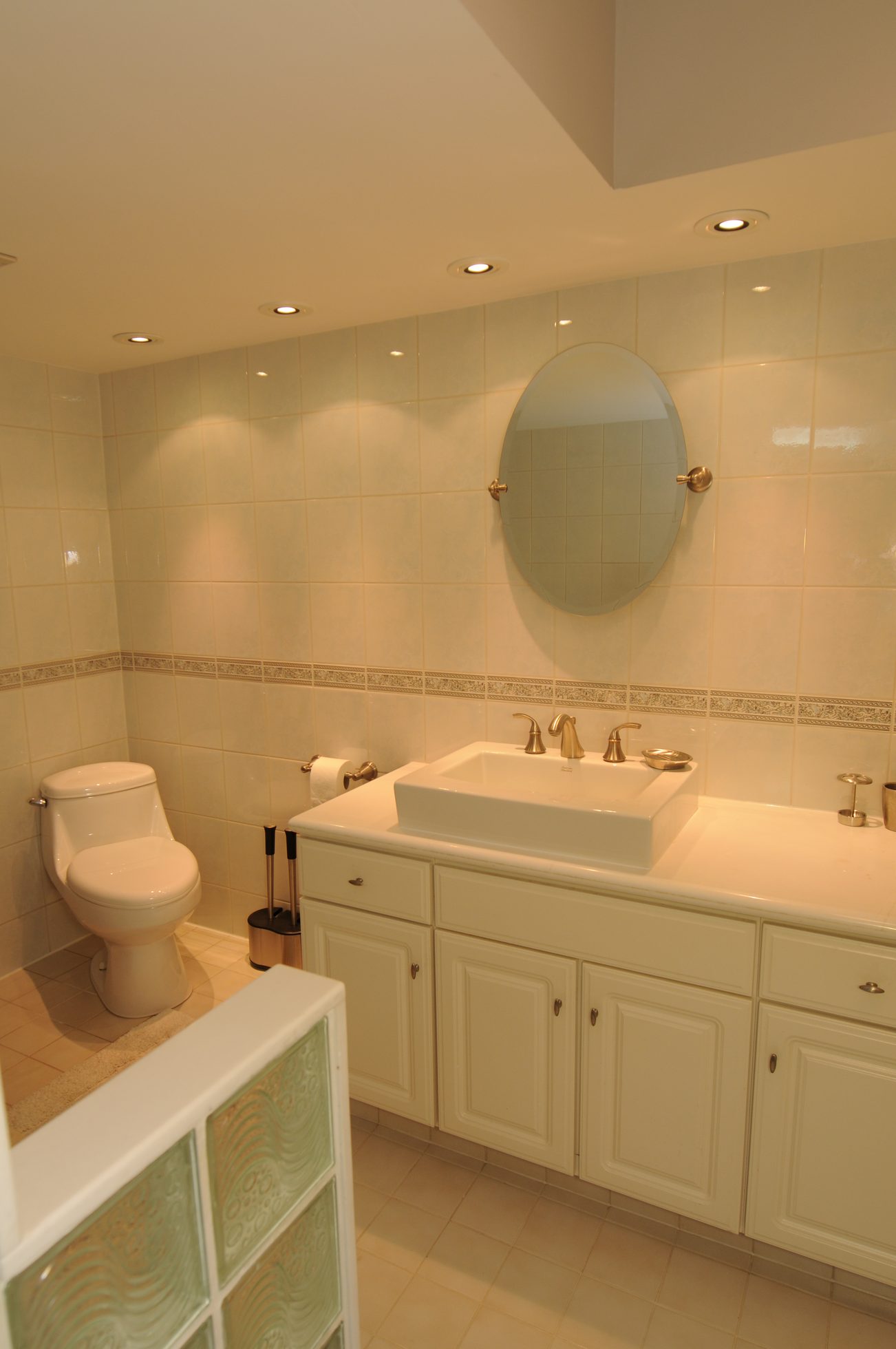 Furnished bathroom with white cabinets, rectangular sink, and round mirror. - 1501 - 845 Chilco Street, Vancouver Downtown