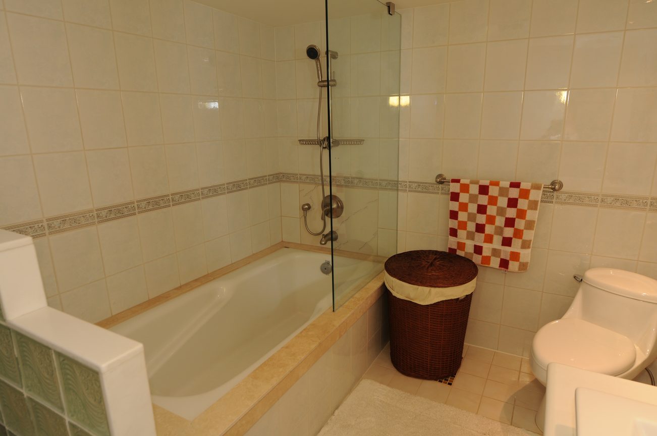 Furnished bathroom with bathtub, glass shower, and checkered towel. - 1501 - 845 Chilco Street, Vancouver Downtown