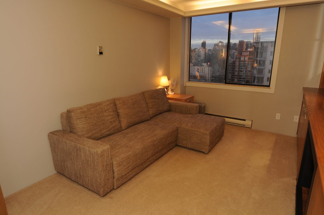 Furnished living room with city view and wooden countertop. - 1501 - 845 Chilco Street, Vancouver Downtown