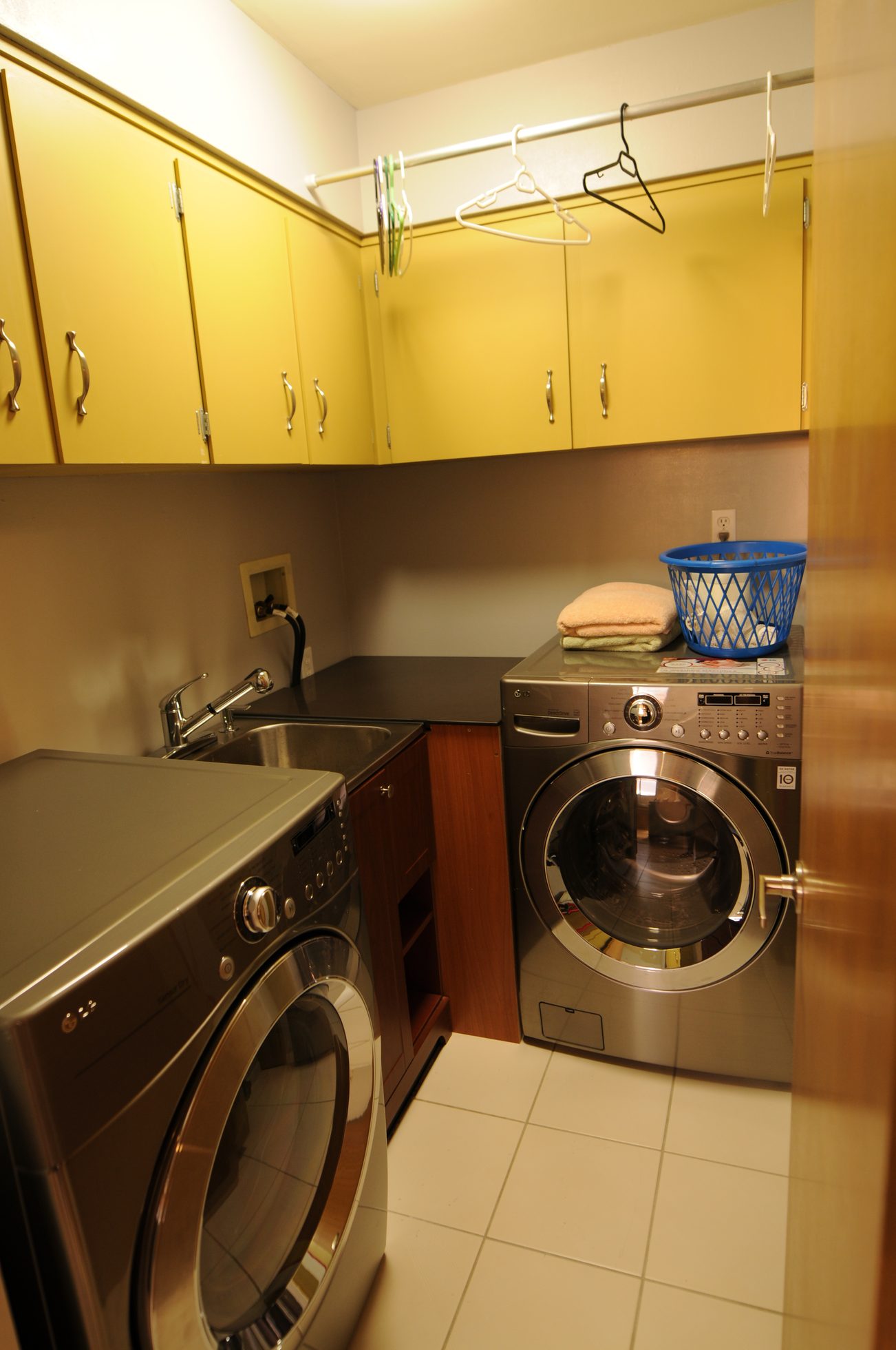 Bright laundry room with stainless steel appliances and hangers above. - 1501 - 845 Chilco Street, Vancouver Downtown