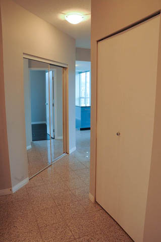 Bright hallway with terrazzo flooring and sliding glass doors leading to a kitchen. - 1808 - 188 East Esplanade, North Vancouver