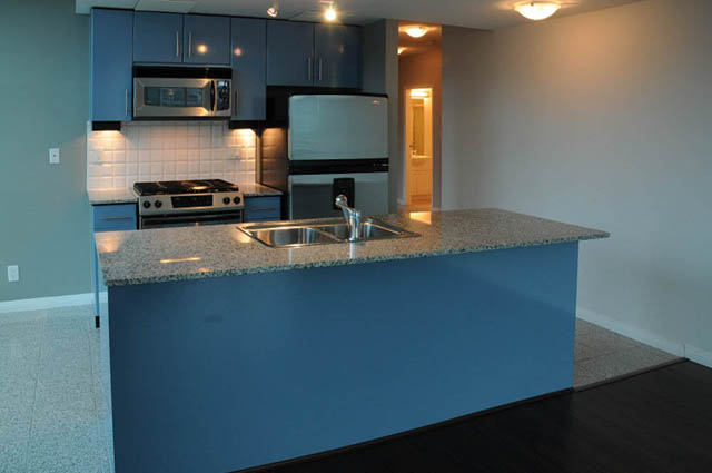 Bright kitchen with granite countertops and dark hardwood floors. - 1808 - 188 East Esplanade, North Vancouver