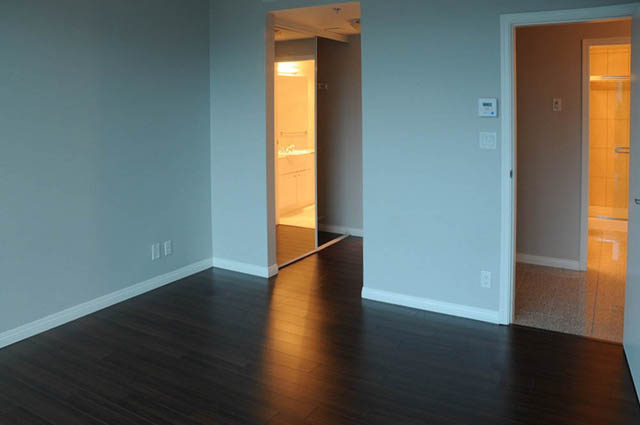 Bright living room with hardwood floors and a view of the kitchen and bathroom. - 1808 - 188 East Esplanade, North Vancouver