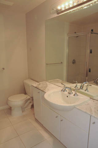 Bright bathroom with white vanity, marble countertop, and shower. - 1808 - 188 East Esplanade, North Vancouver