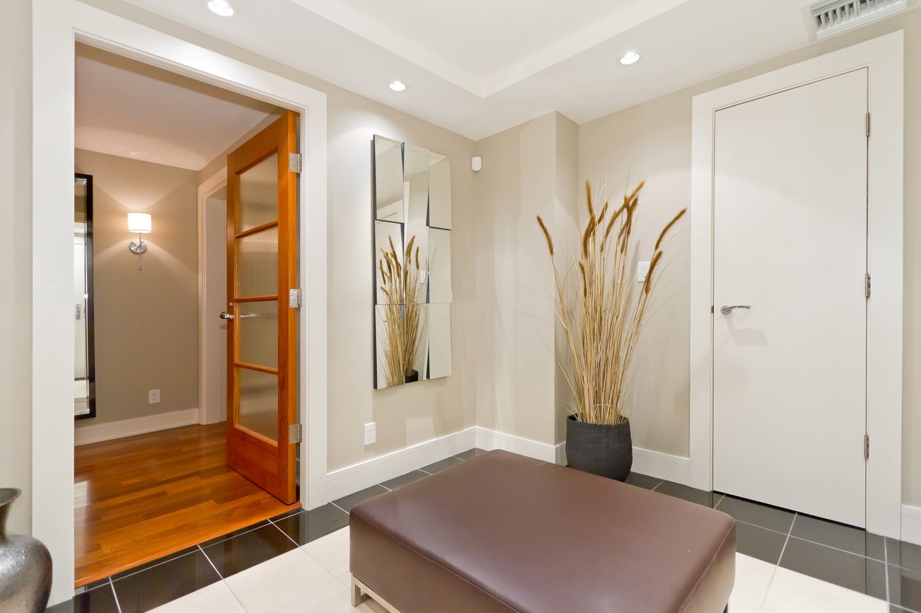 Furnished entryway with modern decor, hardwood floors, and a large mirror. - 302 - 628 Kinghorne Mews, Vancouver Downtown
