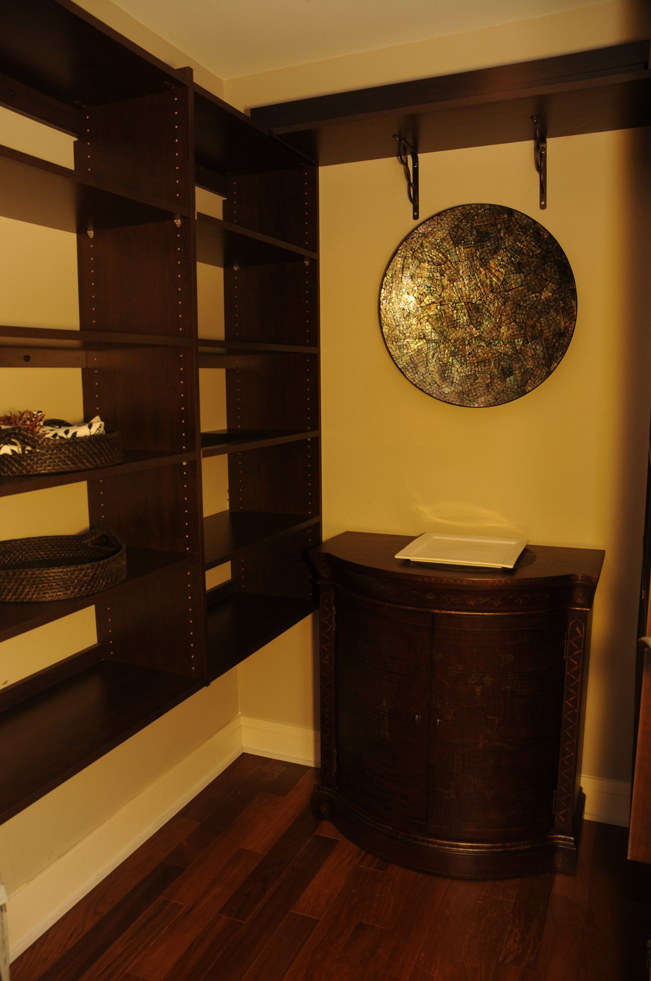 Furnished living area with dark wood shelving, a decorative plate, and a small cabinet. - 302 - 628 Kinghorne Mews, Vancouver Downtown