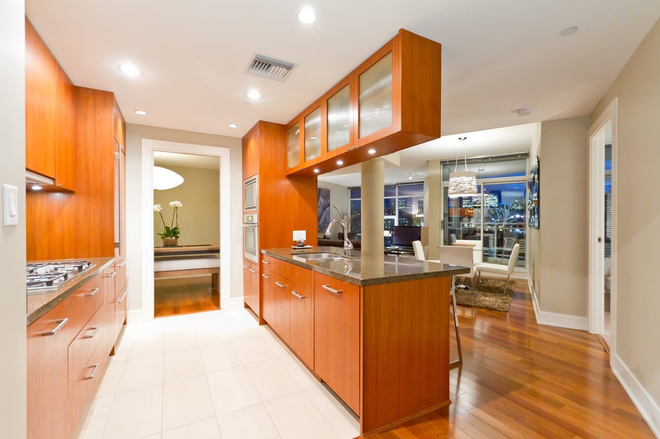 Bright kitchen with modern cabinets, granite countertops, hardwood floors, and a city view. - 302 - 628 Kinghorne Mews, Vancouver Downtown