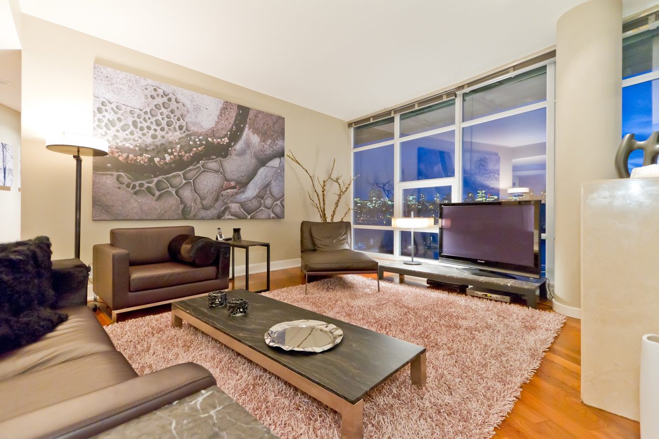 Furnished living room with hardwood floors, city view, and modern decor. - 302 - 628 Kinghorne Mews, Vancouver Downtown