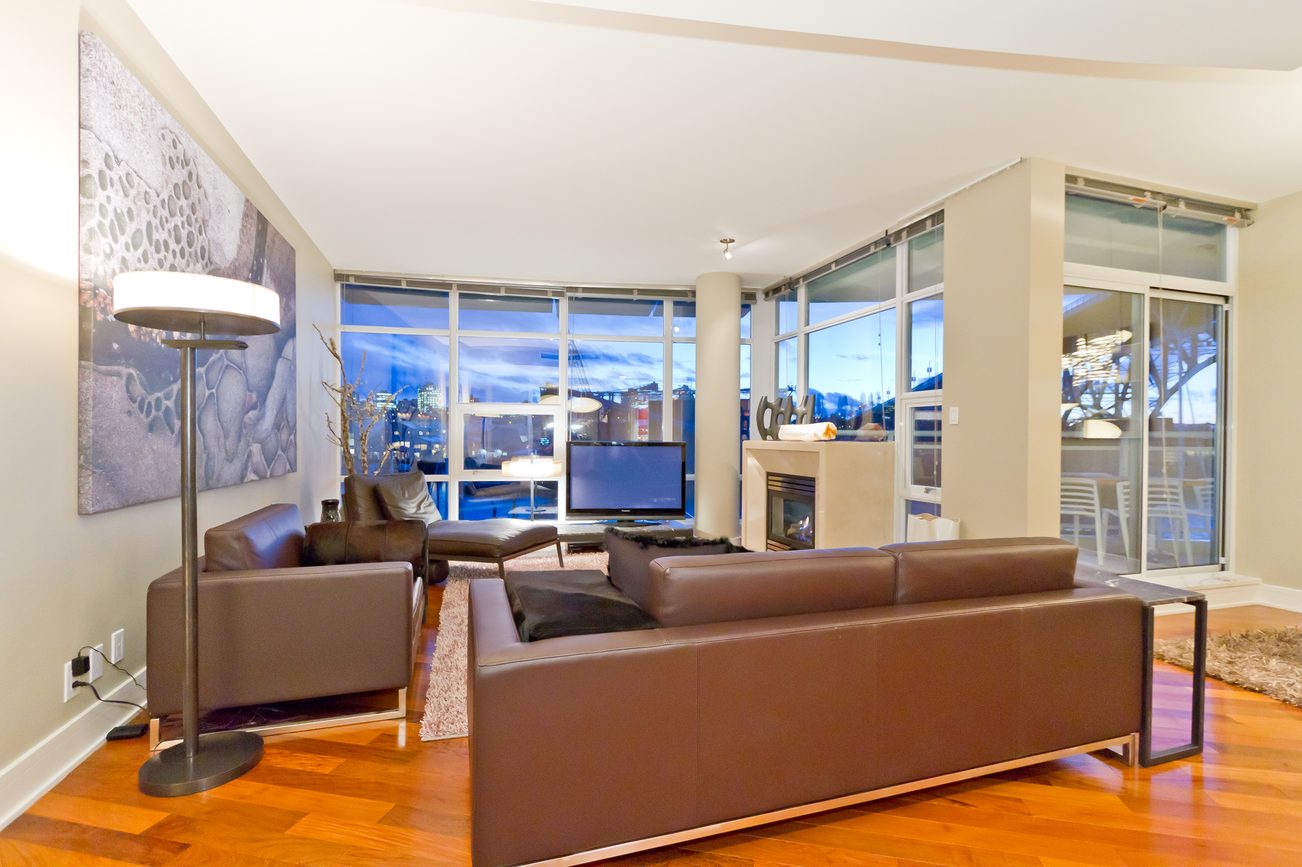 Bright living room with hardwood floors, city view, and modern furniture. - 302 - 628 Kinghorne Mews, Vancouver Downtown