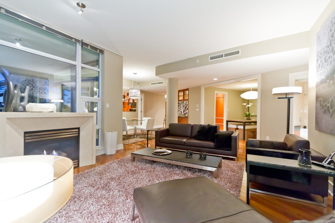 Furnished living room with modern decor, hardwood floors, and a fireplace. - 302 - 628 Kinghorne Mews, Vancouver Downtown