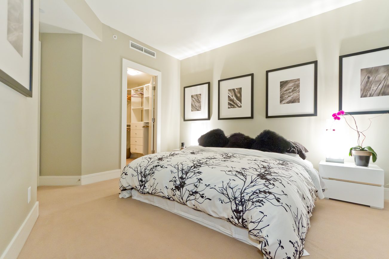 Furnished 2-bedroom condo with modern decor, white bedding, and framed artwork. - 302 - 628 Kinghorne Mews, Vancouver Downtown