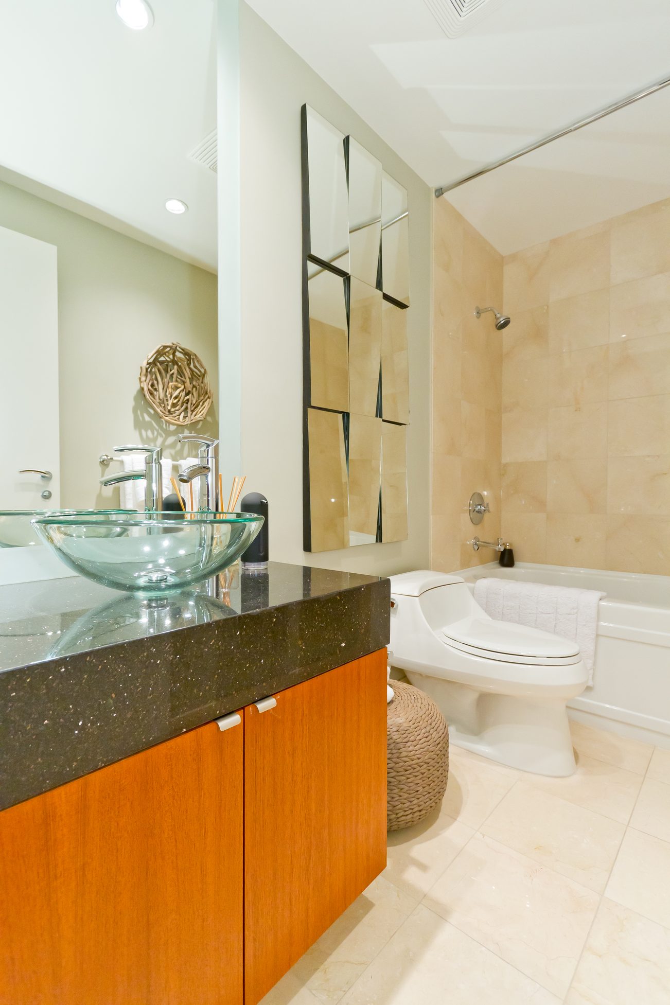 Furnished bathroom with modern glass sink, wooden vanity, and beige tiled walls. - 302 - 628 Kinghorne Mews, Vancouver Downtown