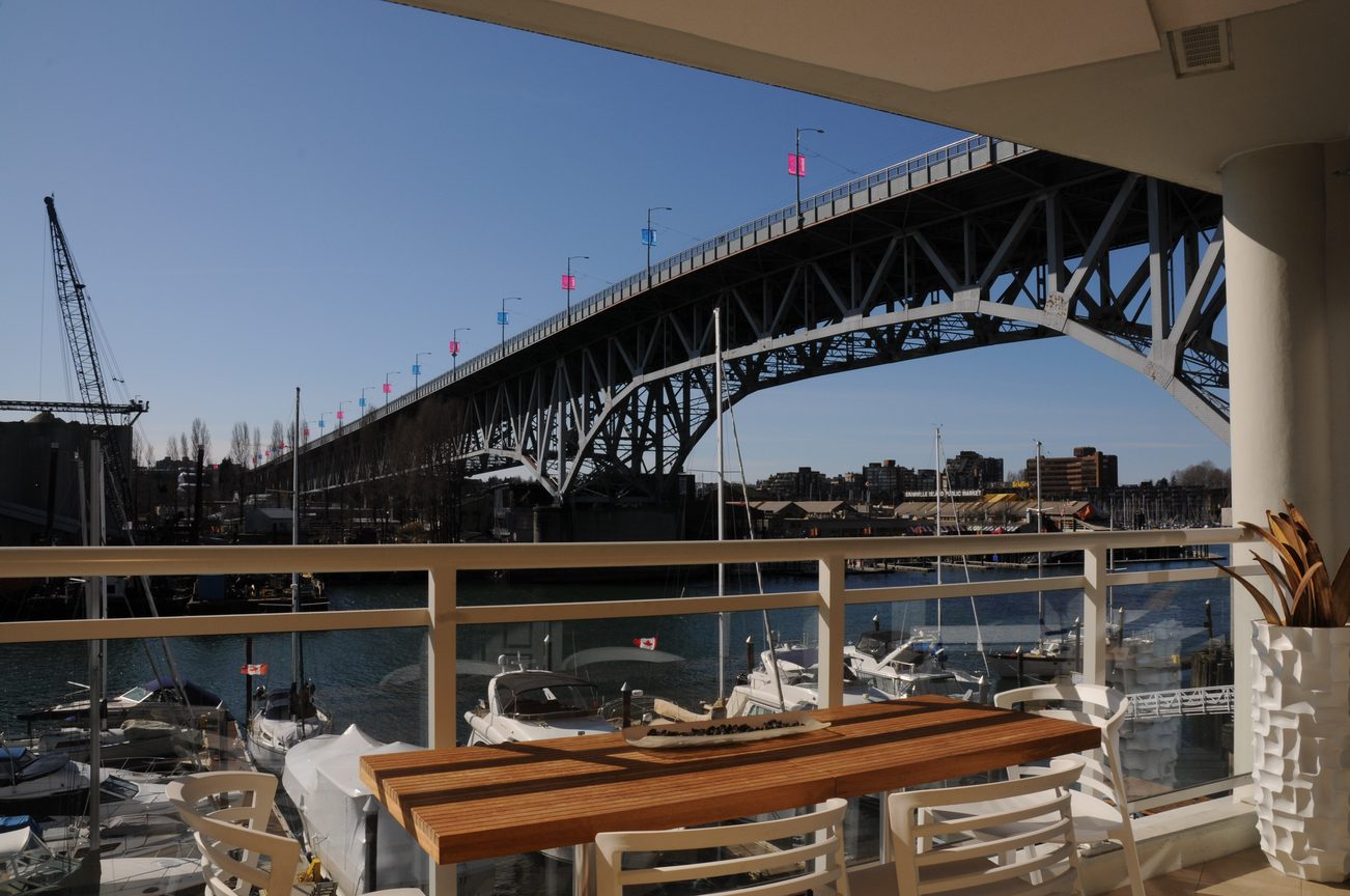 Bright balcony with city view and boats, overlooking a bridge. - 302 - 628 Kinghorne Mews, Vancouver Downtown