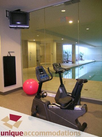 Fitness room with exercise bikes and stability balls, large mirror reflecting pool area. - 302 - 628 Kinghorne Mews, Vancouver Downtown
