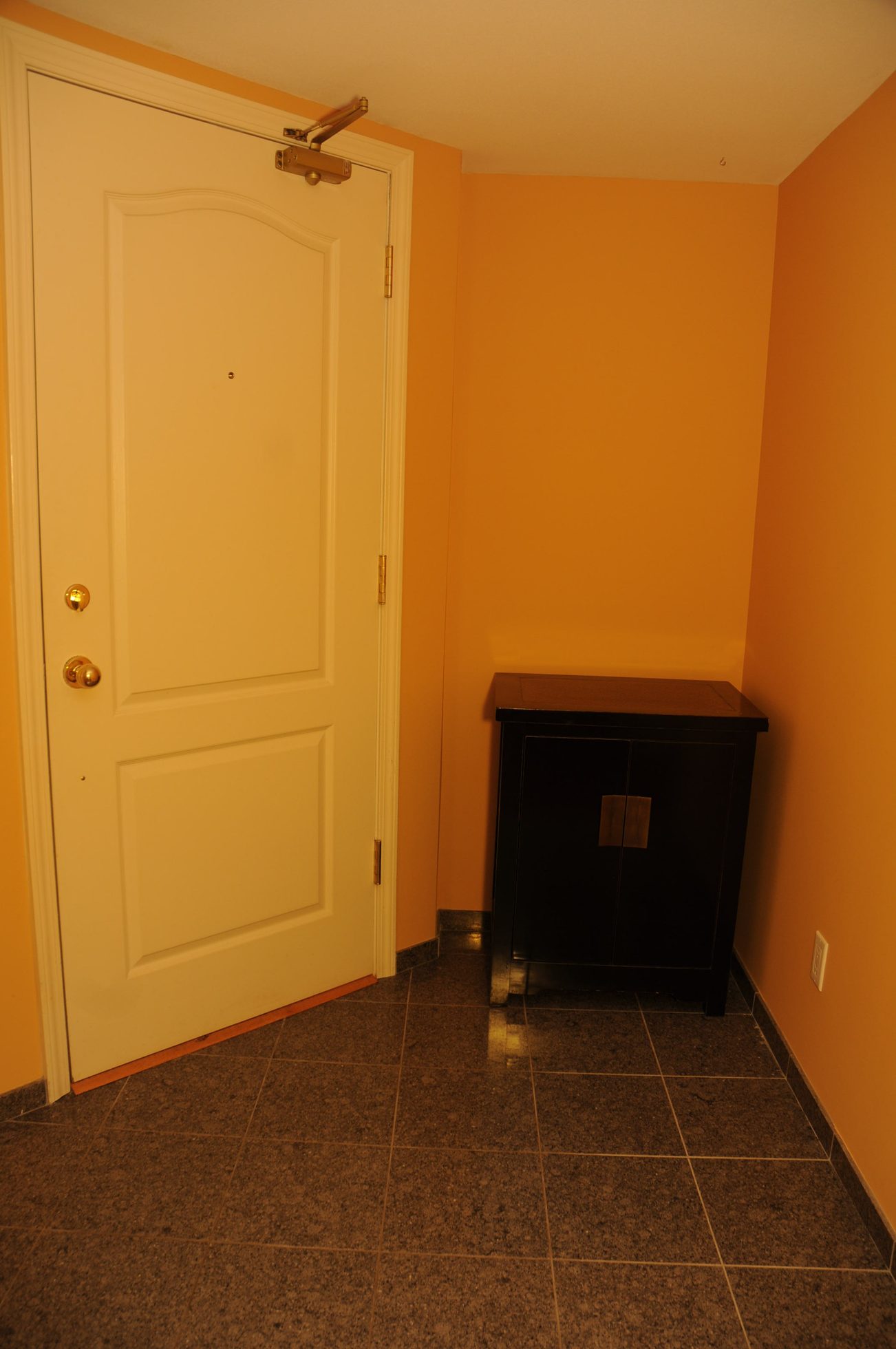 Entryway with white door and black cabinet, tiled floor. - 1705-867 Hamilton Street, Vancouver Downtown