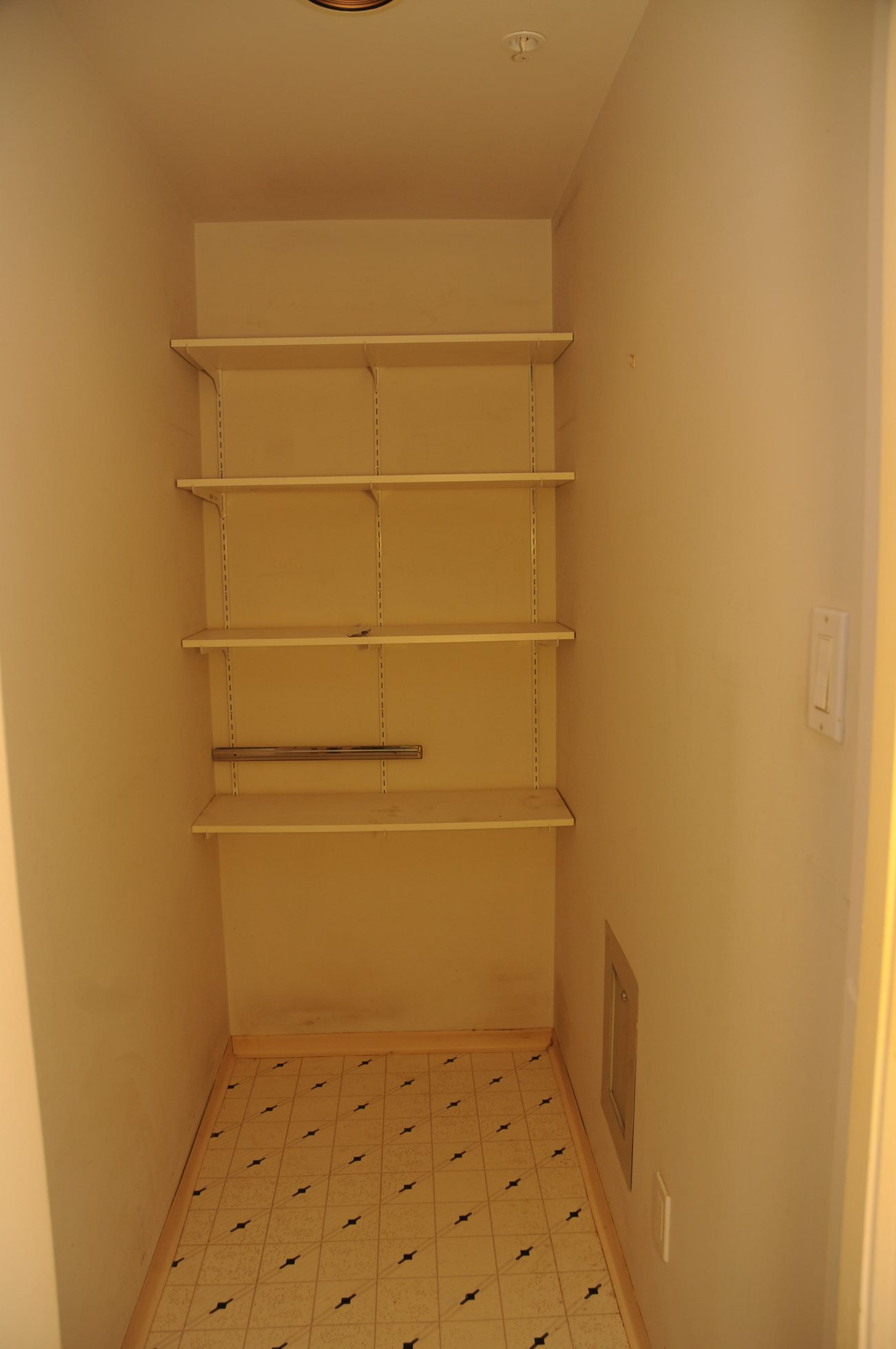 Den with empty shelves and patterned tile floor. - 1705-867 Hamilton Street, Vancouver Downtown