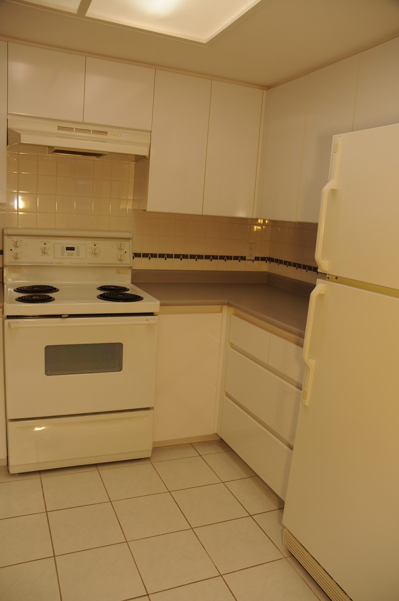 Bright kitchen with white appliances and tiled backsplash, clean and ready for move-in. - 1705-867 Hamilton Street, Vancouver Downtown