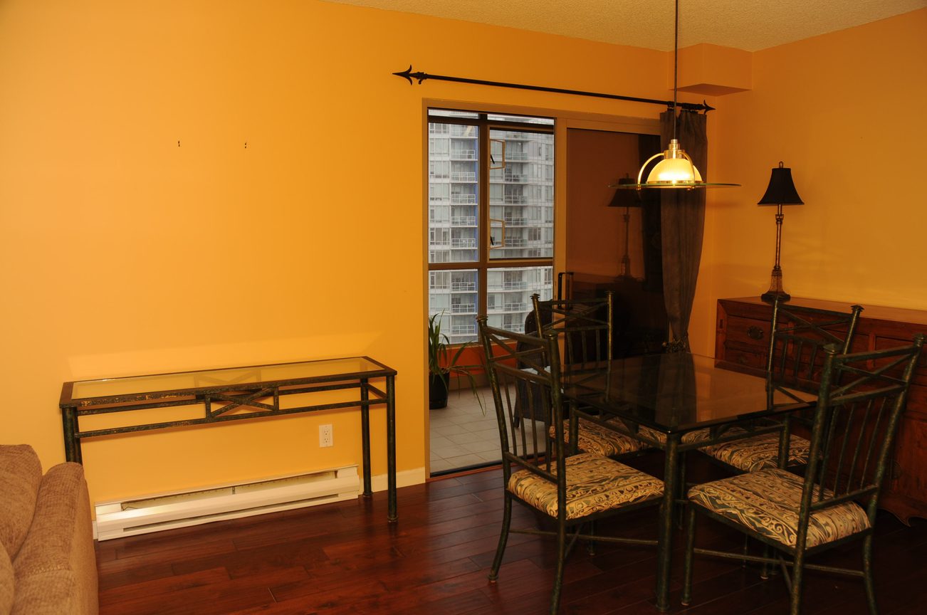 Furnished dining area with hardwood floors and city view through large windows. - 1705-867 Hamilton Street, Vancouver Downtown