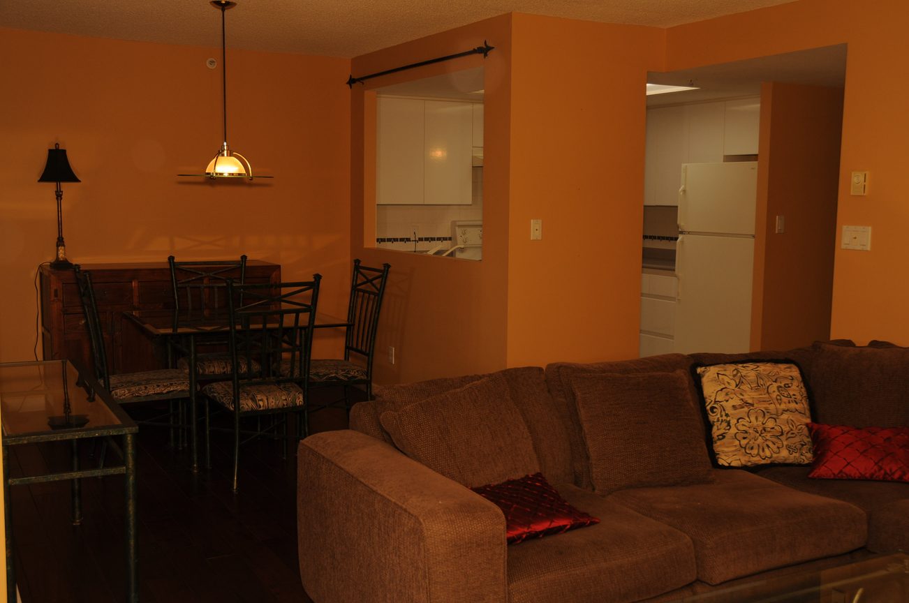 Furnished living room with brown couches and dining area in the background. - 1705-867 Hamilton Street, Vancouver Downtown