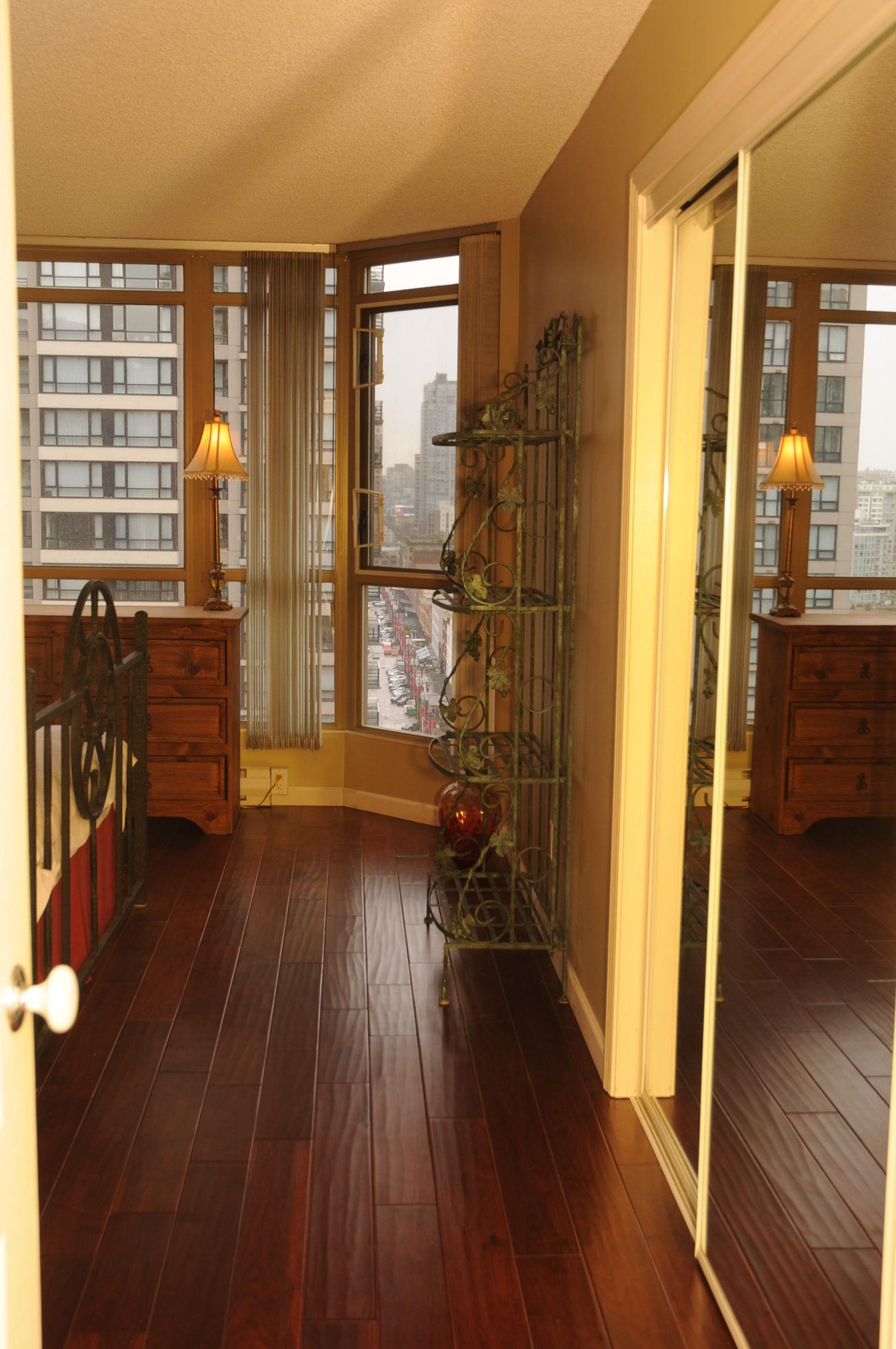 Bright bedroom with hardwood floors, city view, and mirrored closet doors. - 1705-867 Hamilton Street, Vancouver Downtown