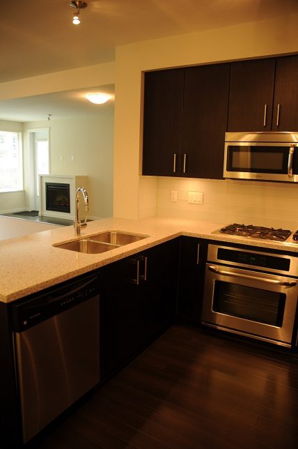 Bright kitchen with granite countertops, stainless steel appliances, and hardwood floors. - G07 - 119 West 22nd Avenue, North Vancouver