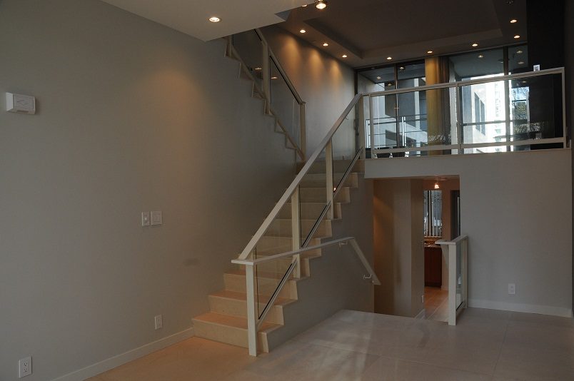 Bright open-concept living area with modern staircase and glass railing. - 1275 Alberni Street, Vancouver Downtown