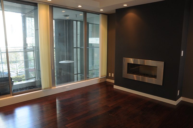 Bright living room with hardwood floors, large windows, and a modern fireplace. - 1275 Alberni Street, Vancouver Downtown