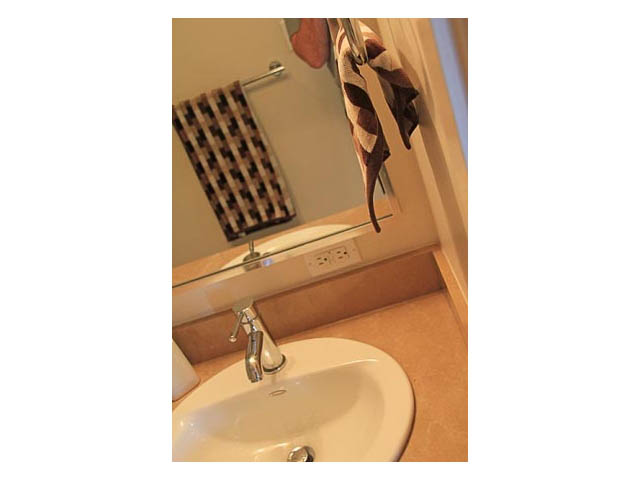 Bathroom with beige countertop and sink, checkered towel visible. - 2602-928 Homer Street, Vancouver Downtown