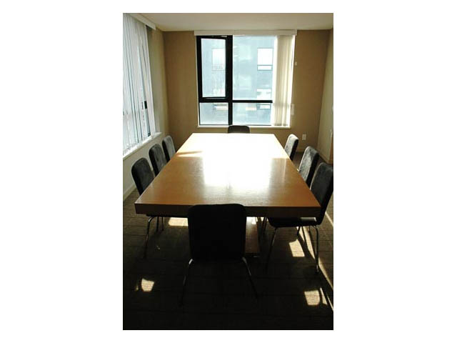 Bright dining area with large windows and wooden table, natural light flooding in. - 2602-928 Homer Street, Vancouver Downtown