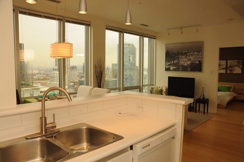 Bright kitchen with white countertops, hardwood floors, and a city view. - 1910 - 989 Nelson Street, Vancouver Downtown