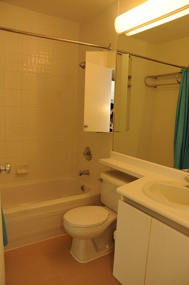 Bathroom with white fixtures, tiled walls, and a green shower curtain. - 1910 - 989 Nelson Street, Vancouver Downtown