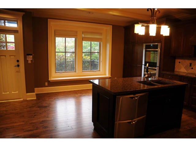 Bright kitchen with dark wood cabinets, granite countertops, and hardwood floors. - 3570 West 42nd Avenue, Vancouver West Side