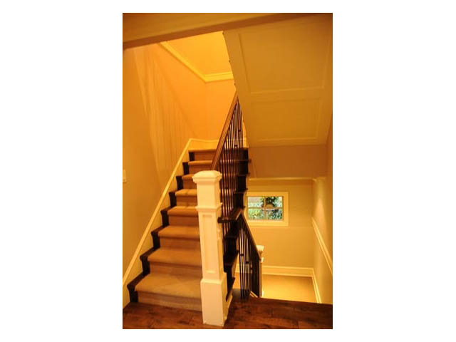Staircase with wooden banister and carpeted steps leading to upper level. - 3570 West 42nd Avenue, Vancouver West Side