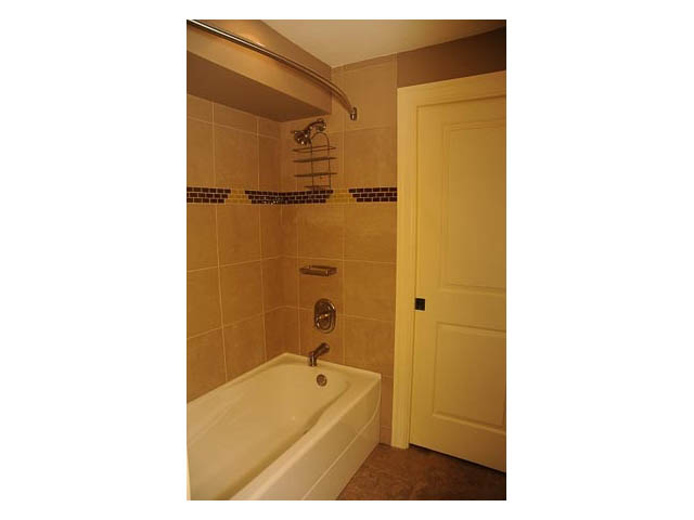 Bathroom with bathtub, tiled walls, and shower curtain rod. - 3570 West 42nd Avenue, Vancouver West Side